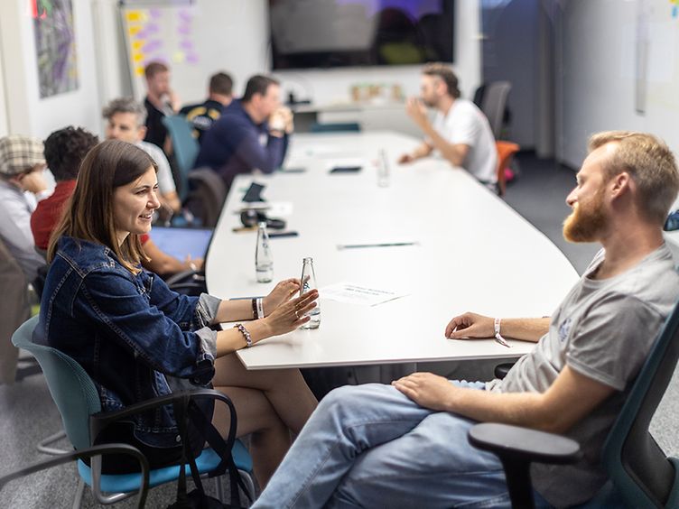 Several people are sitting around a meeting table.